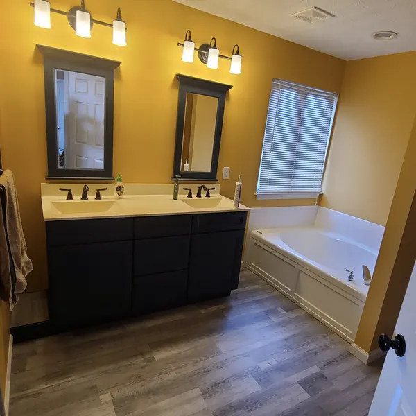 Bathroom with dark double vanity and soaking tub