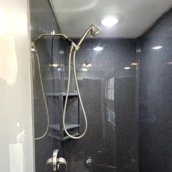 Shower with dark cultured marble wall surround