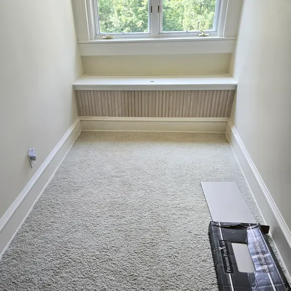Bedroom with newly installed light carpet and white trim