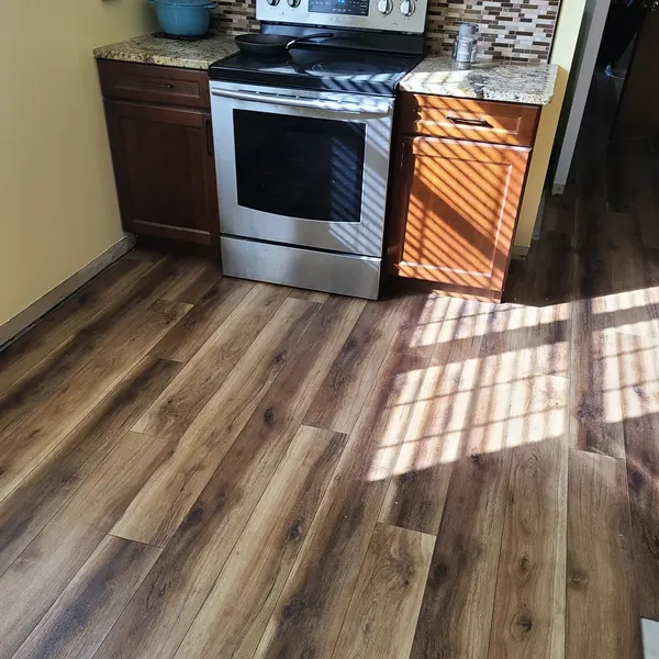 Wood-look vinyl plank flooring in a kitchen with wood cabinets