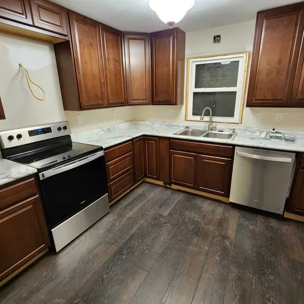 L-shaped kitchen with cherry-stained cabinets and stainless appliances