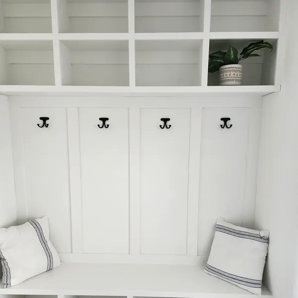 White built-in mudroom bench with coat hooks