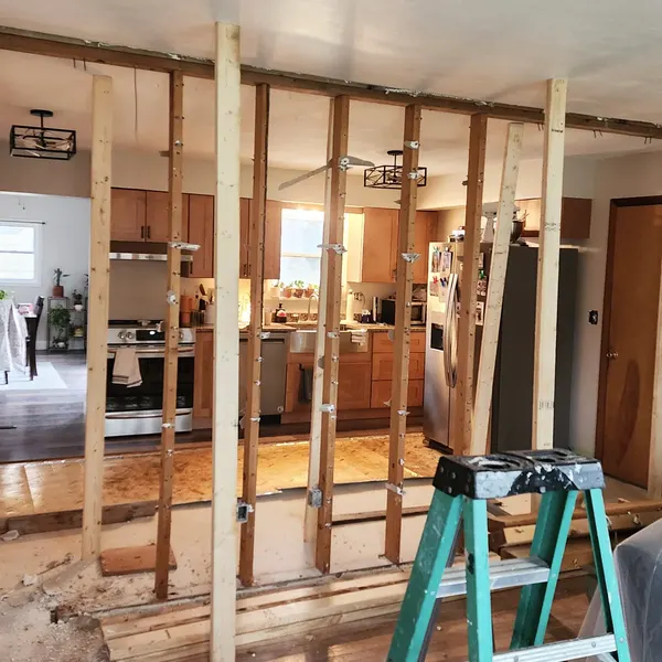 Wall framing opened up between a living area and kitchen during a remodel